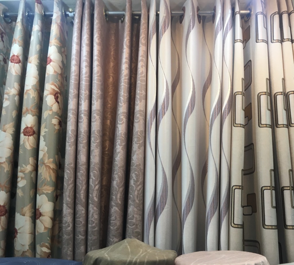 ผ้าม่านสวยๆมากมาย เย็บเป็นตัวอย่างให้เห็นลวดลาย หน้าร้านมีผ้าโชว์เป็นม้วนๆ
