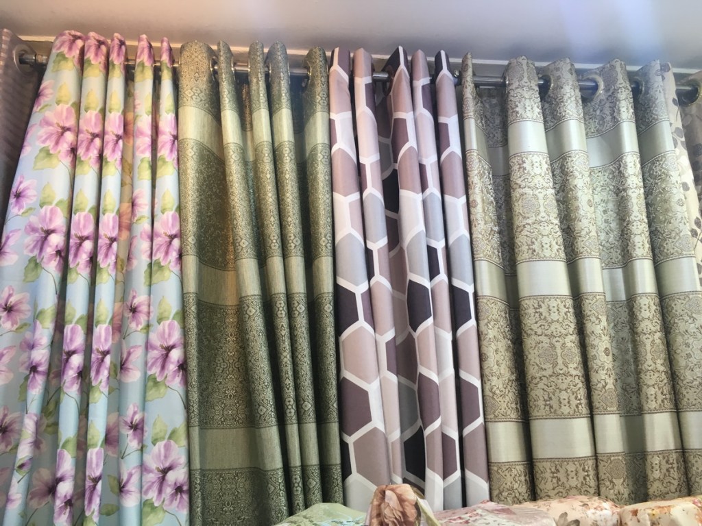 ผ้าม่านสวยๆมากมาย เย็บเป็นตัวอย่างให้เห็นลวดลาย หน้าร้านมีผ้าโชว์เป็นม้วนๆ